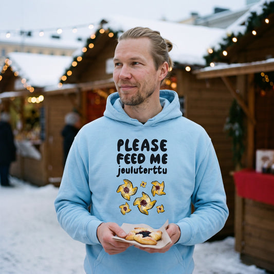Feed me Joulutorttu Finnish Holiday Hoodie in light blue, worn by Joonas with a joulutorttu at a Christmas market, Very Finnish Problems