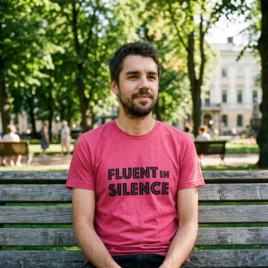 Man on park bench in Helsinki wearing raspberry Fluent in Silence t-shirt, Very Finnish Problems