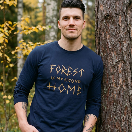 Forest Is Home long sleeve tee in navy, worn by Eetu leaning on a pine trunk in an autumn birch forest, Very Finnish Problems