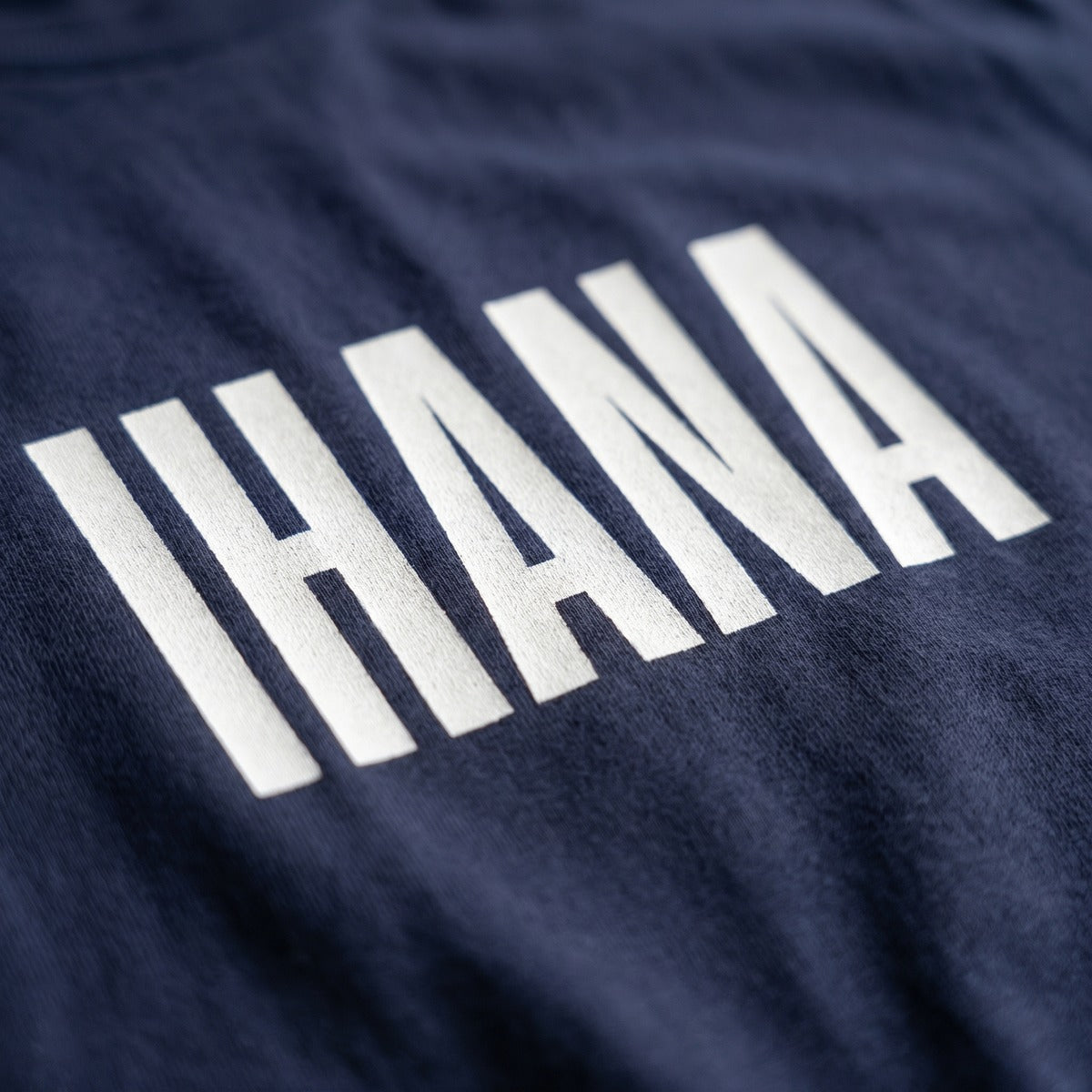 Close-up of the white IHANA print on a navy t-shirt, Very Finnish Problems