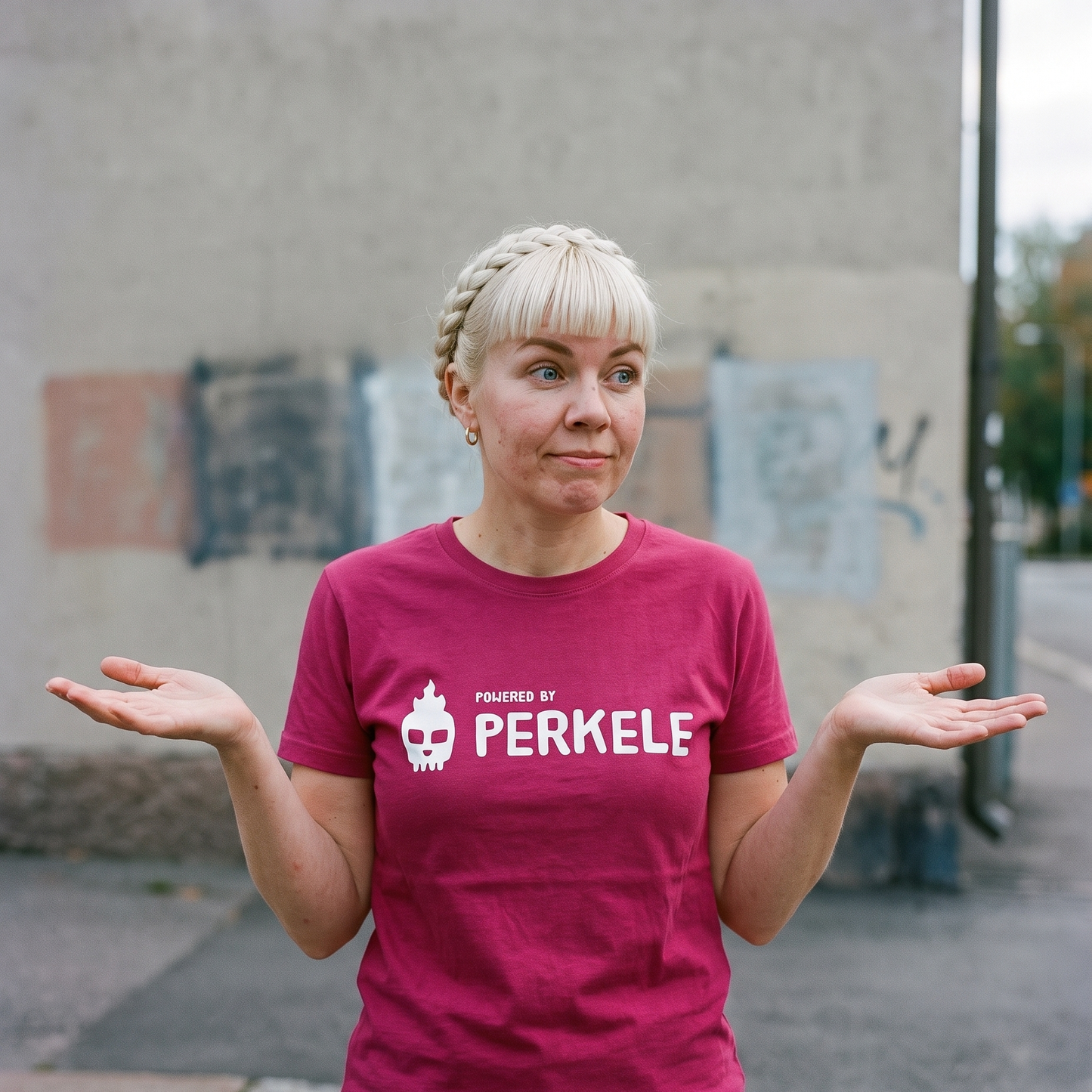 Powered by perkele t-shirt in berry, worn by Venla shrugging on a Finnish city street, Very Finnish Problems