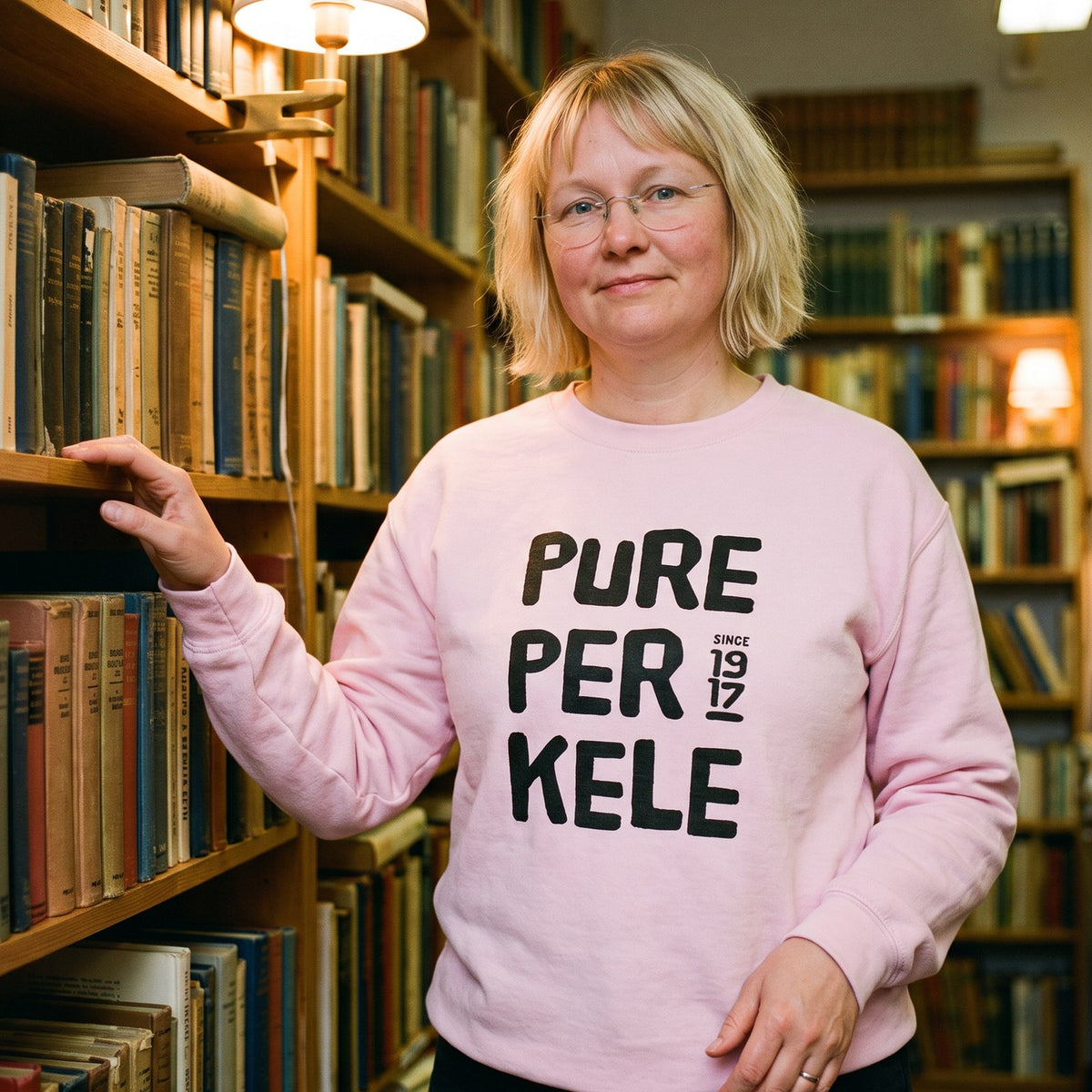 Pure Perkele since 1917 sweatshirt in light pink, worn by Marika in a second-hand bookshop, Very Finnish Problems