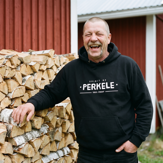 Spirit of Perkele hoodie in black, worn by Juha beside a stacked woodpile, Very Finnish Problems