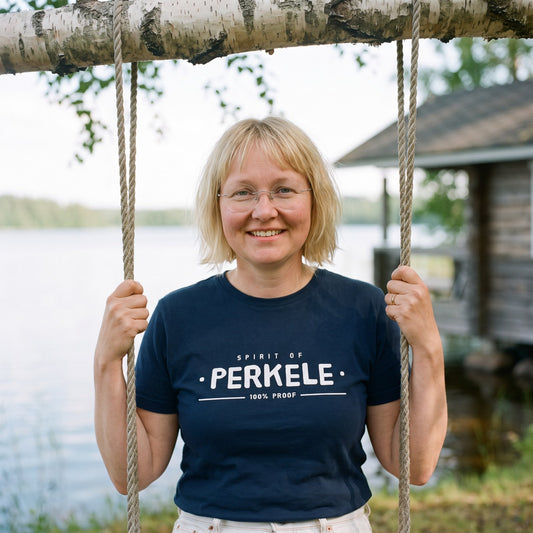 Spirit of Perkele organic t-shirt in french navy, worn by Marika on a birch swing, Very Finnish Problems