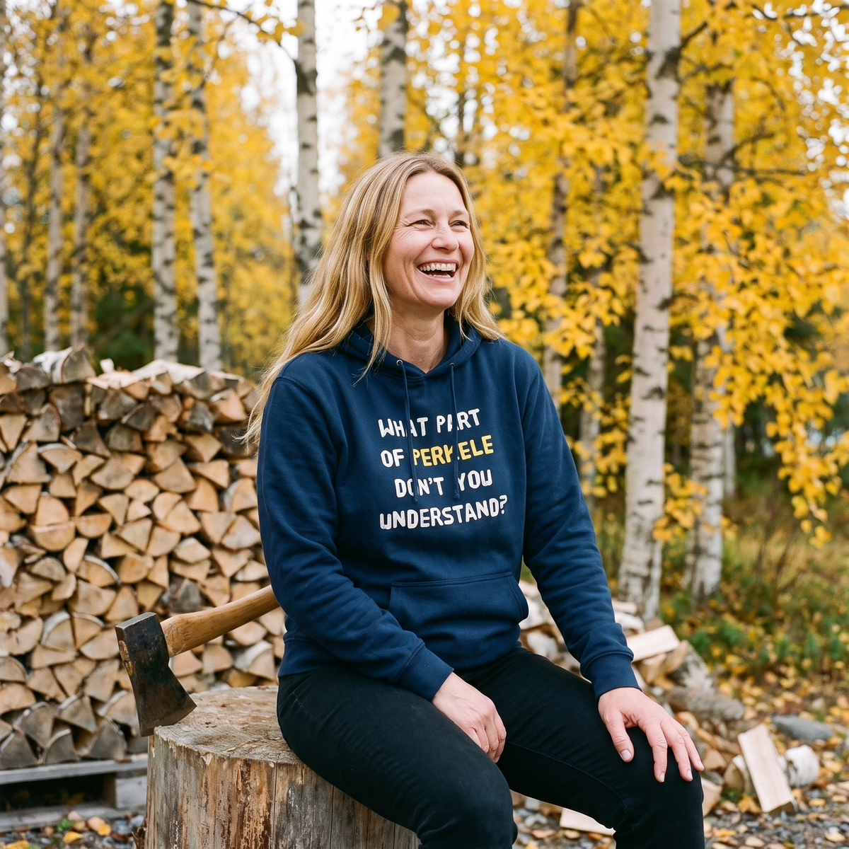 What Part of Perkele hoodie in navy, worn by Elina laughing on a chopping block by a woodpile, Very Finnish Problems