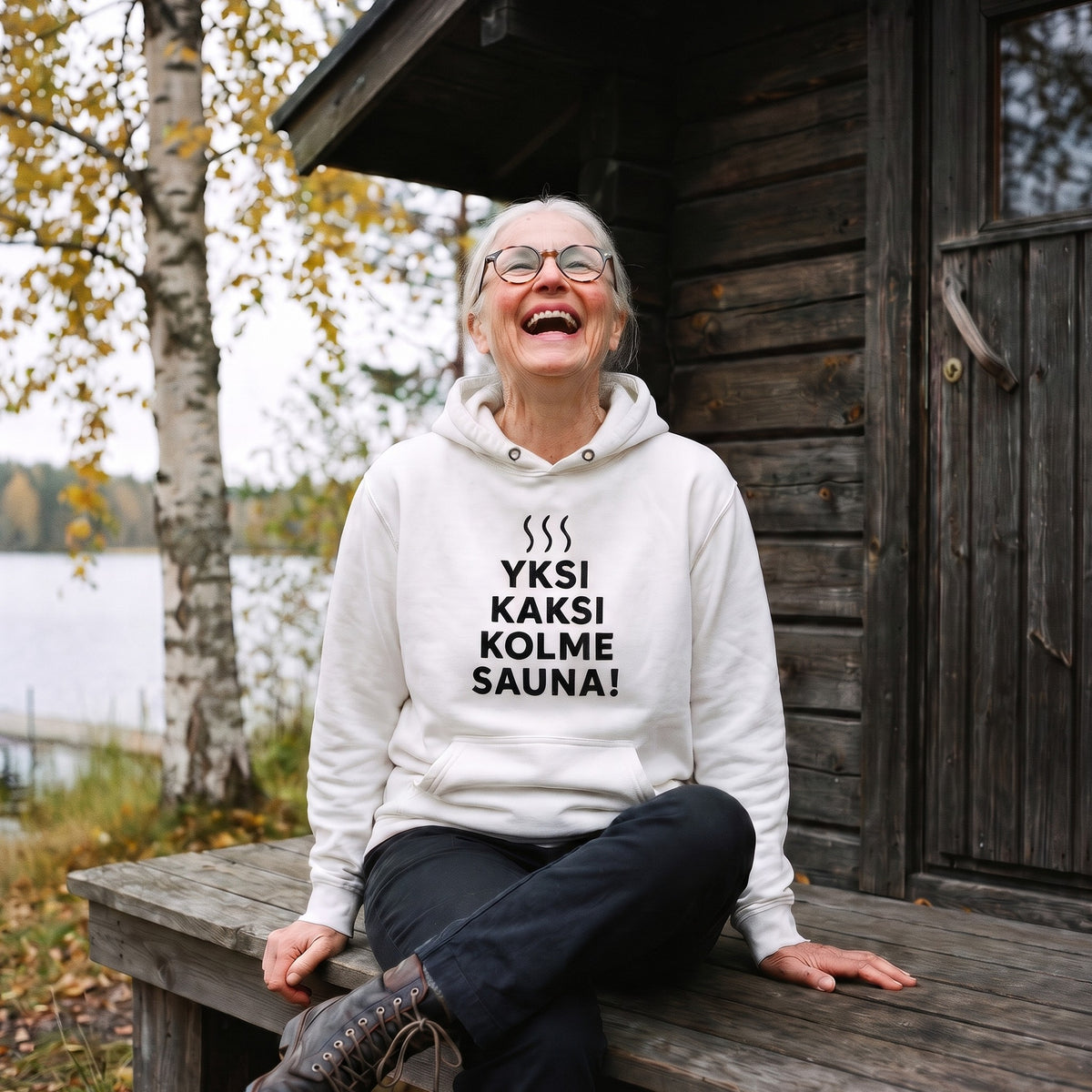 Yksi, kaksi, kolme, sauna! hoodie in white with black print, worn by a woman on a sauna bench, Very Finnish Problems