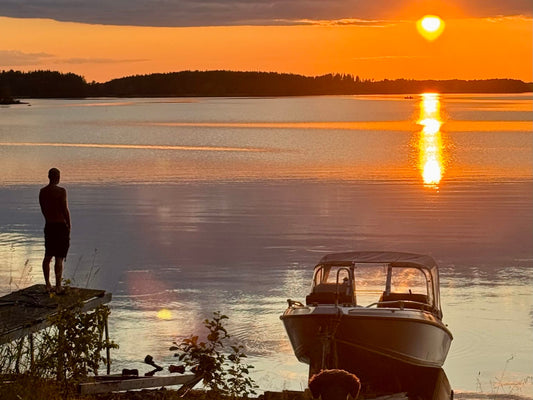 A Finnish summer cottage on the edge of a still lake at dusk
