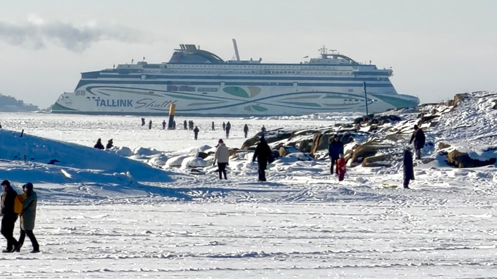 People walking on the frozen sea in Helsinki as a Tallink ferry passes behind in winter, photo by Joel Willans