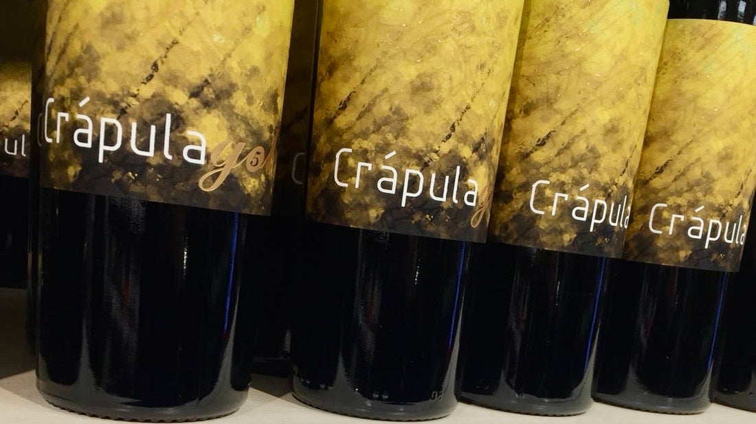 Bottles of Crapula red wine lined up on a shelf in a Finnish Alko store