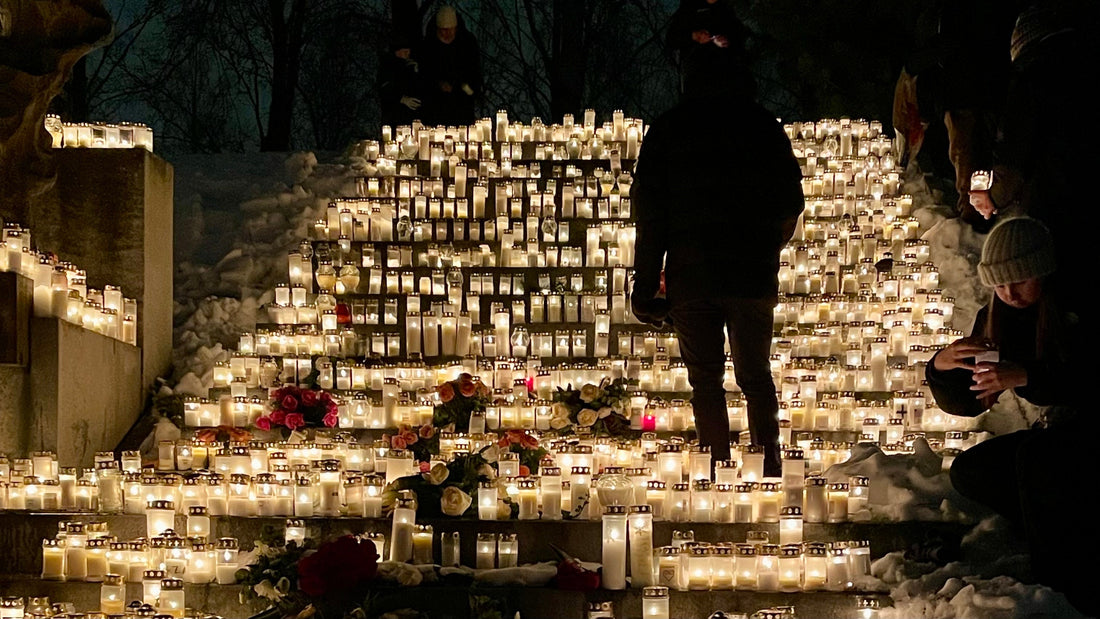 Hundreds of memorial candles glowing on snow-covered cemetery steps on Christmas Eve in Finland, photo by Joel Willans
