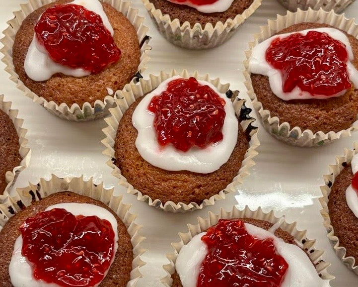 Runeberg cakes topped with white icing and a ring of raspberry jam