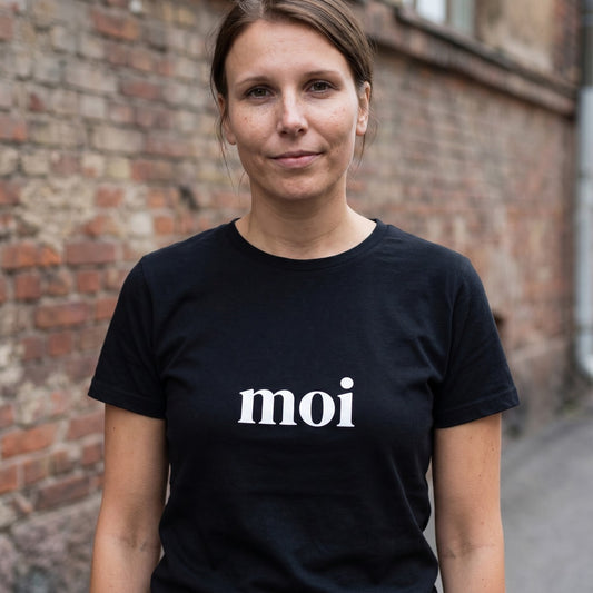 Woman on a Helsinki street wearing the black Moi Finnish greeting t-shirt