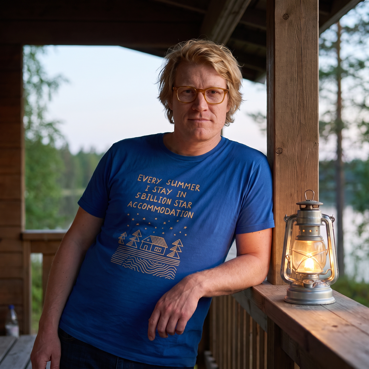 5 Billion Star Accommodation Finnish t-shirt in blue, worn by Tuomas on a summer cabin porch at dusk, Very Finnish Problems