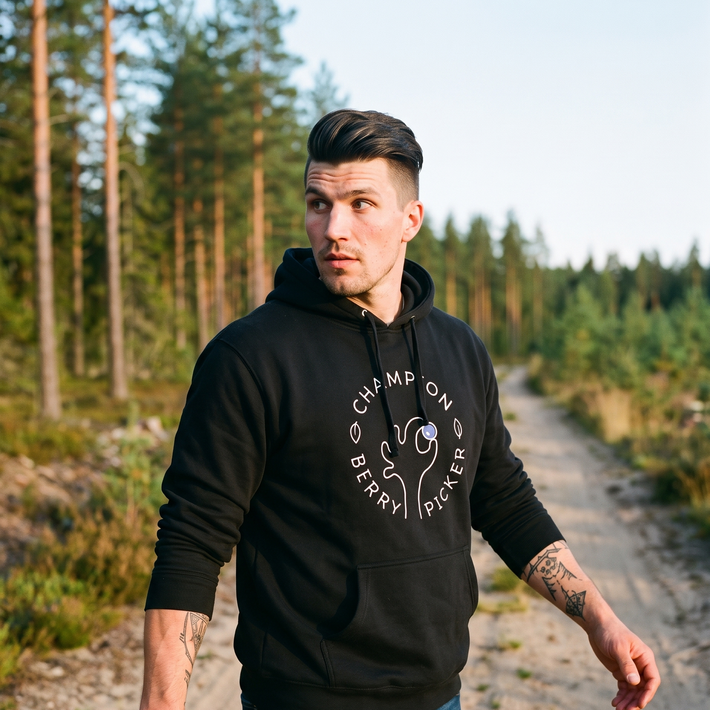 Champion Blueberry Picker hoodie in black, worn by Eetu on a Finnish forest track in the evening, Very Finnish Problems