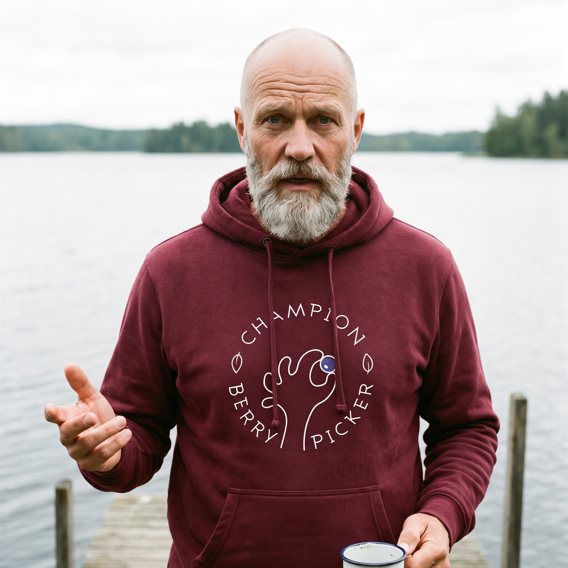 Champion Blueberry Picker hoodie in maroon, worn by Mikko on a wooden jetty by a Finnish lake, Very Finnish Problems