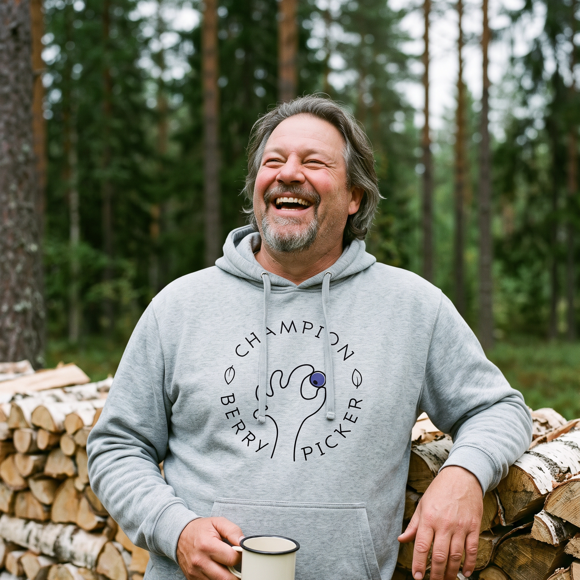 Champion Blueberry Picker hoodie in sport grey, worn by Jojelli laughing beside a cottage woodpile, Very Finnish Problems