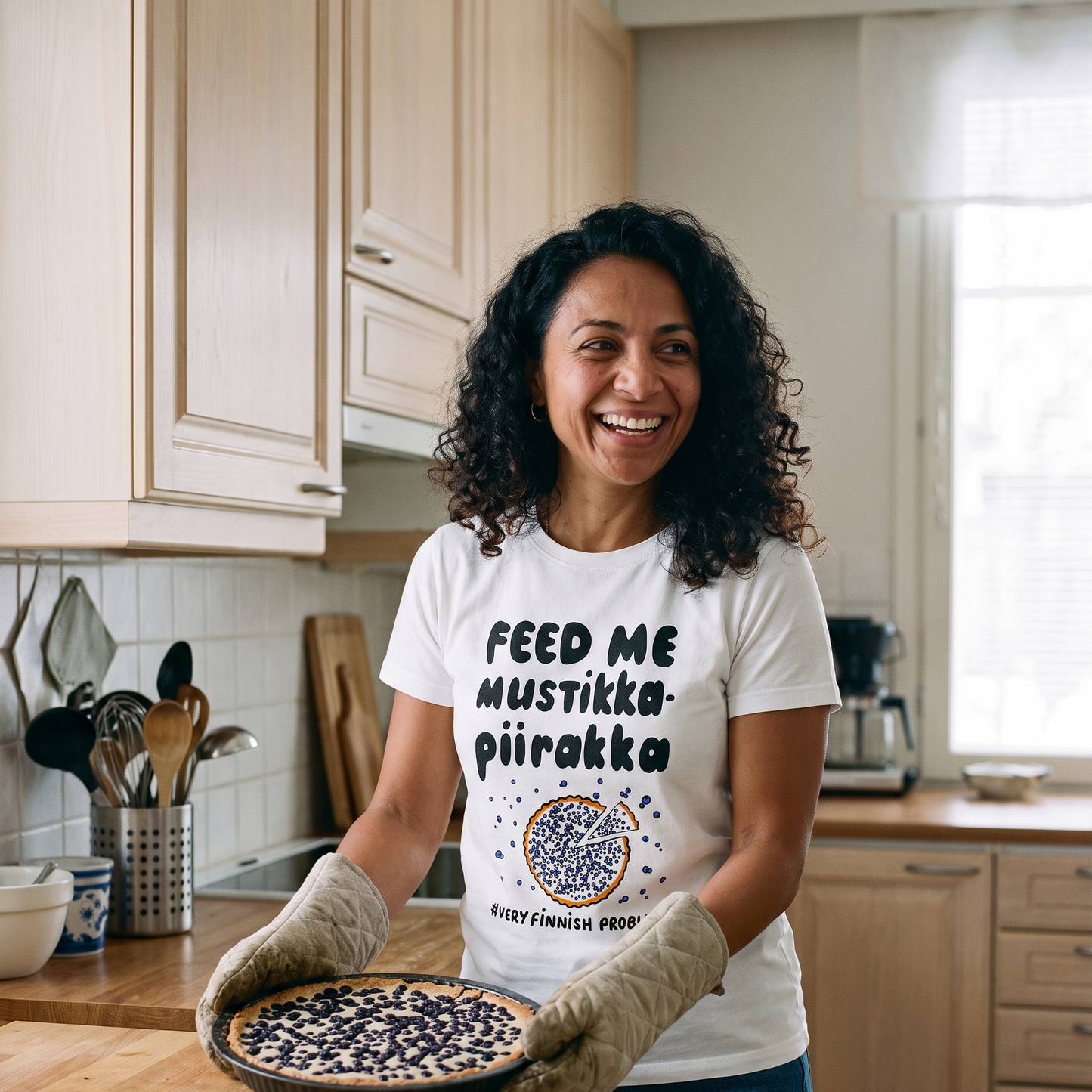 Feed Me Mustikkapiirakka t-shirt in white, worn by Nea taking a blueberry pie out of the oven, Very Finnish Problems