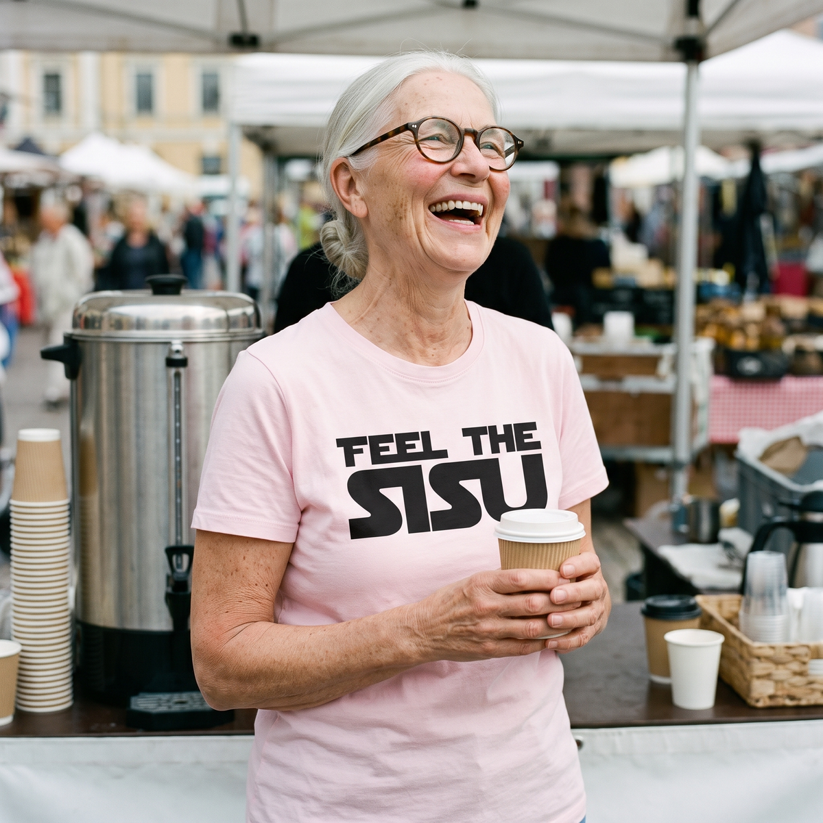 Feel the sisu Finnish culture t-shirt in pink, worn by Raija laughing at a market coffee stall, Very Finnish Problems