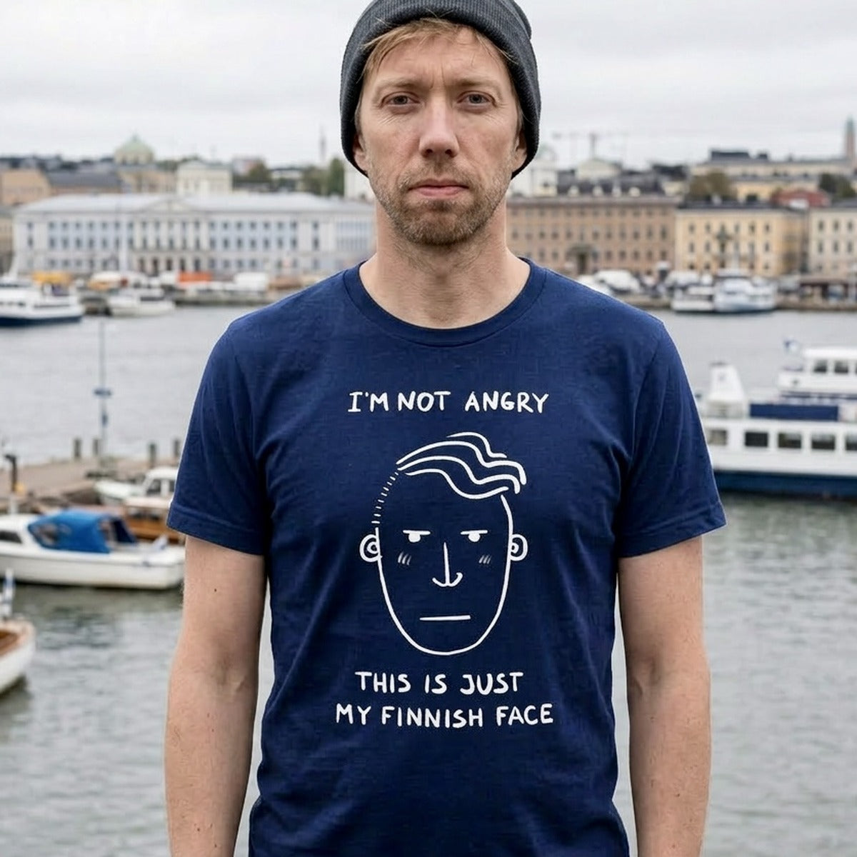 Man in Helsinki harbour wearing navy Finnish Face Humour t-shirt, I'm Not Angry This Is Just My Finnish Face, Very Finnish Problems