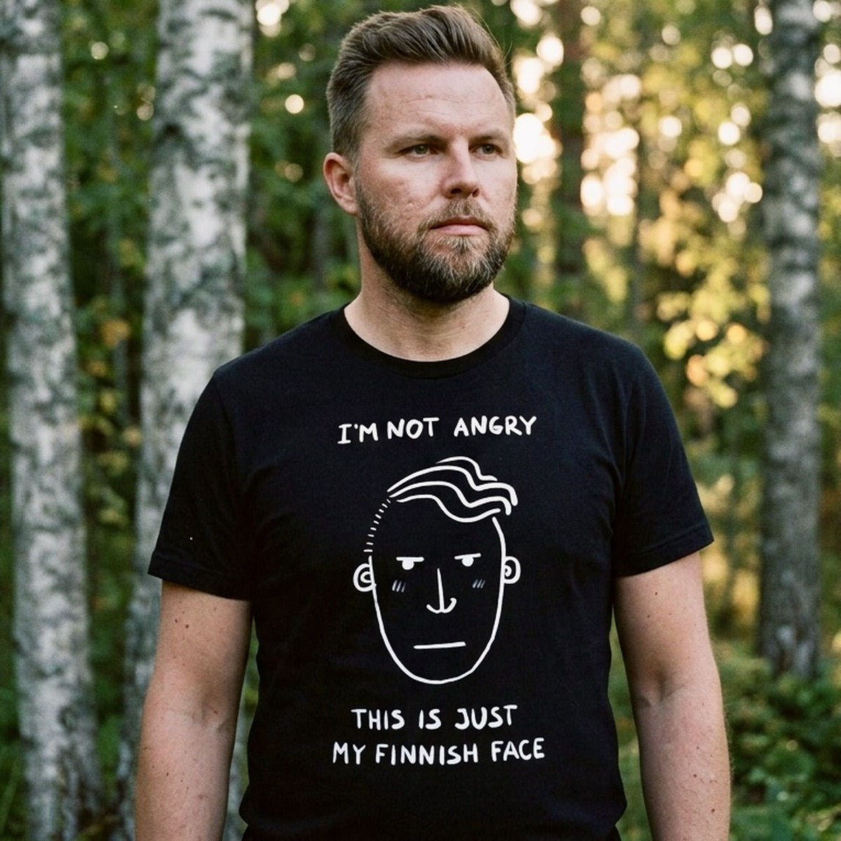 Man in Finnish forest wearing black Finnish Face Humour t-shirt, I'm Not Angry This Is Just My Finnish Face, Very Finnish Problems