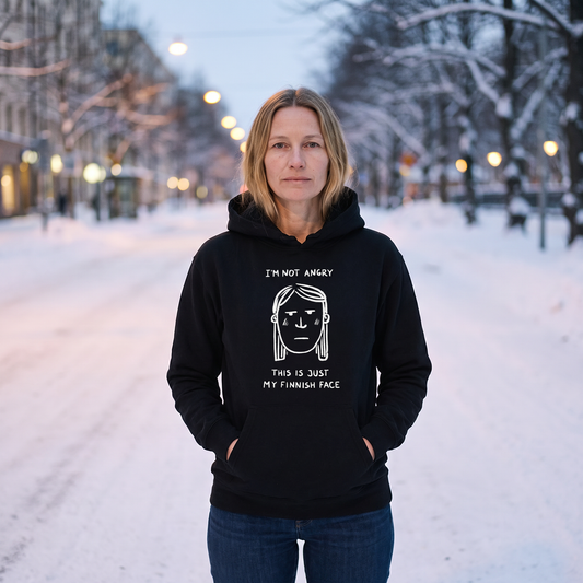 Finnish Face women's hoodie in black, worn by Elina on a snowy Helsinki street, Very Finnish Problems