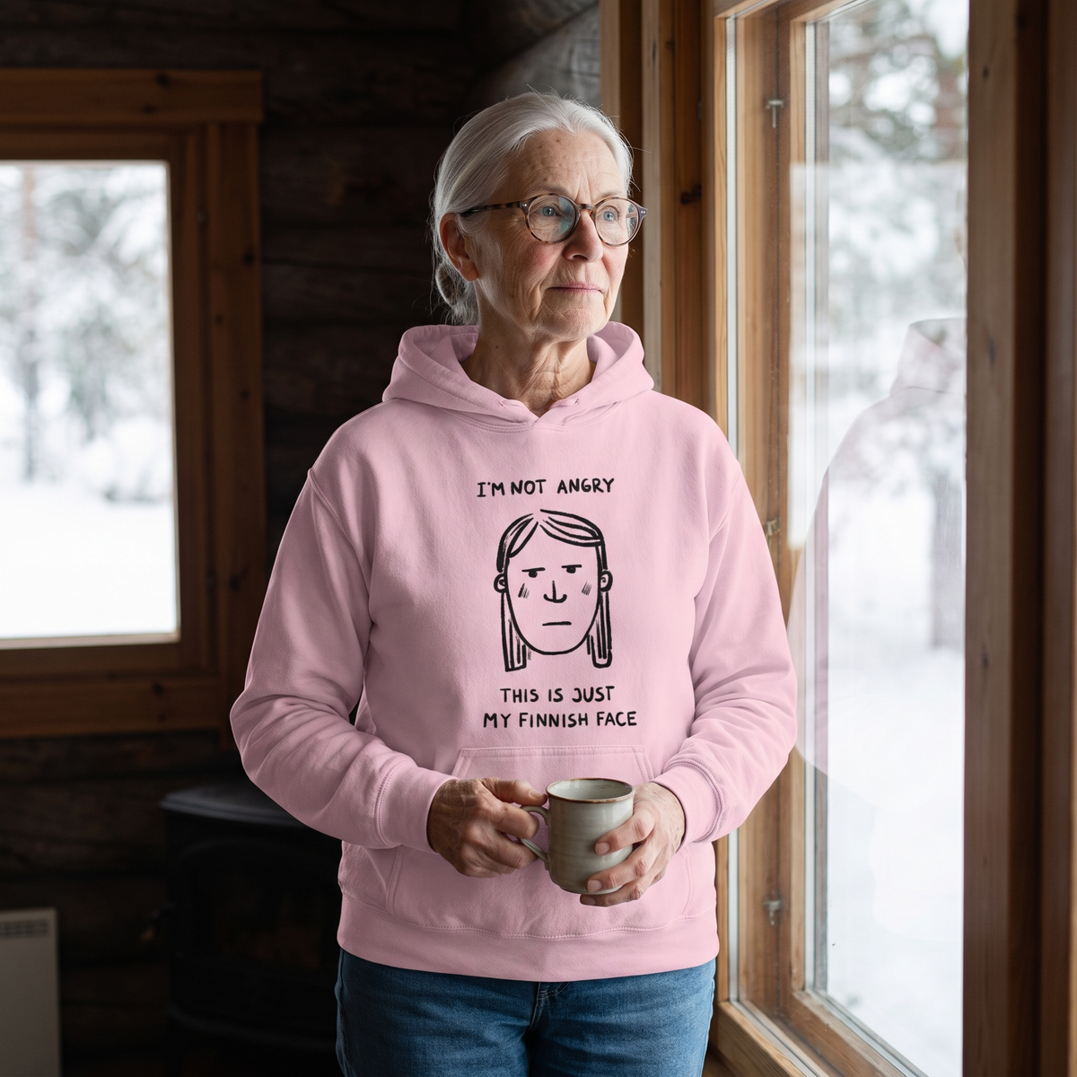 Finnish Face women's hoodie in light pink, worn by Raija at a cabin window in winter, Very Finnish Problems