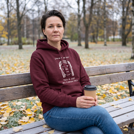 Finnish Face women's hoodie in maroon, worn by Katja on a park bench in autumn, Very Finnish Problems