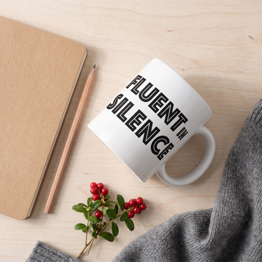 Fluent in Silence mug on a birch table with a notebook, pencil and lingonberries, Very Finnish Problems