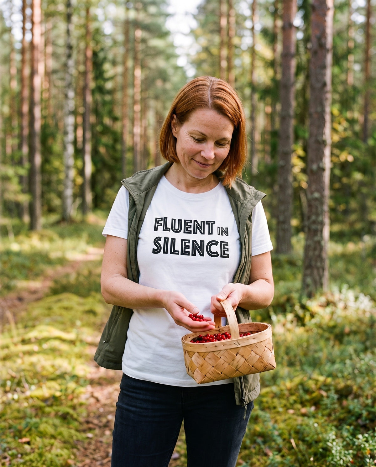 Fluent in Silence t-shirt in white, worn by Sanna picking lingonberries in a forest, Very Finnish Problems