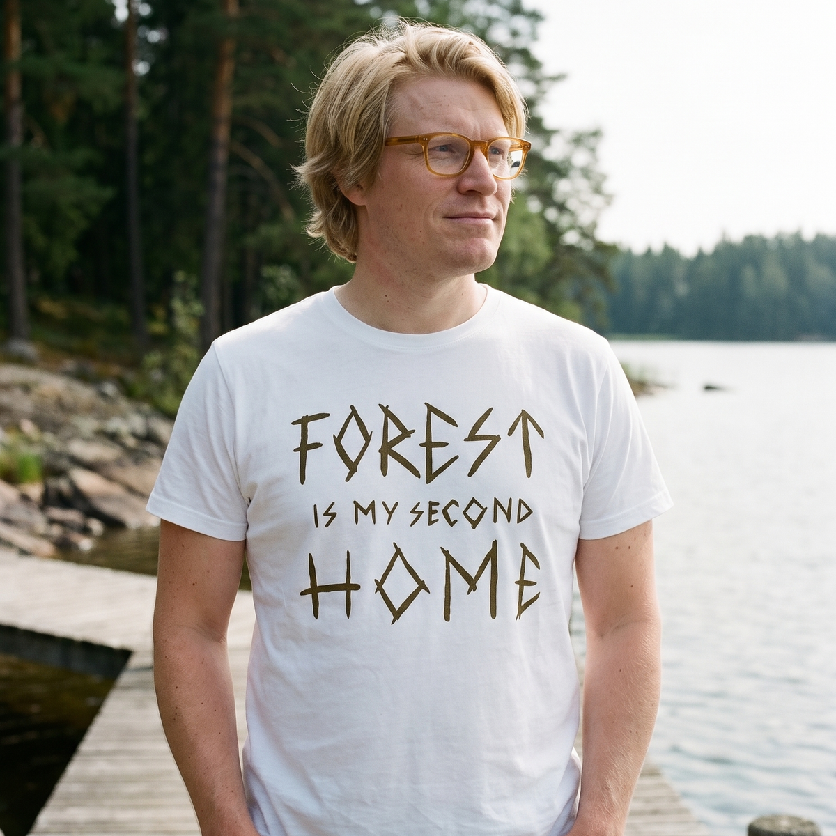 Forest Is Home t-shirt in white, worn by Tuomas on a short lake jetty in Finland, Very Finnish Problems
