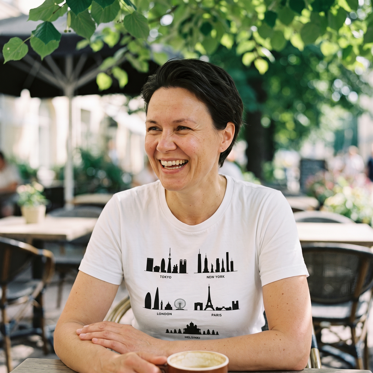 Helsinki Skyline t-shirt in white, worn by Katja on a summer cafe terrace, Very Finnish Problems