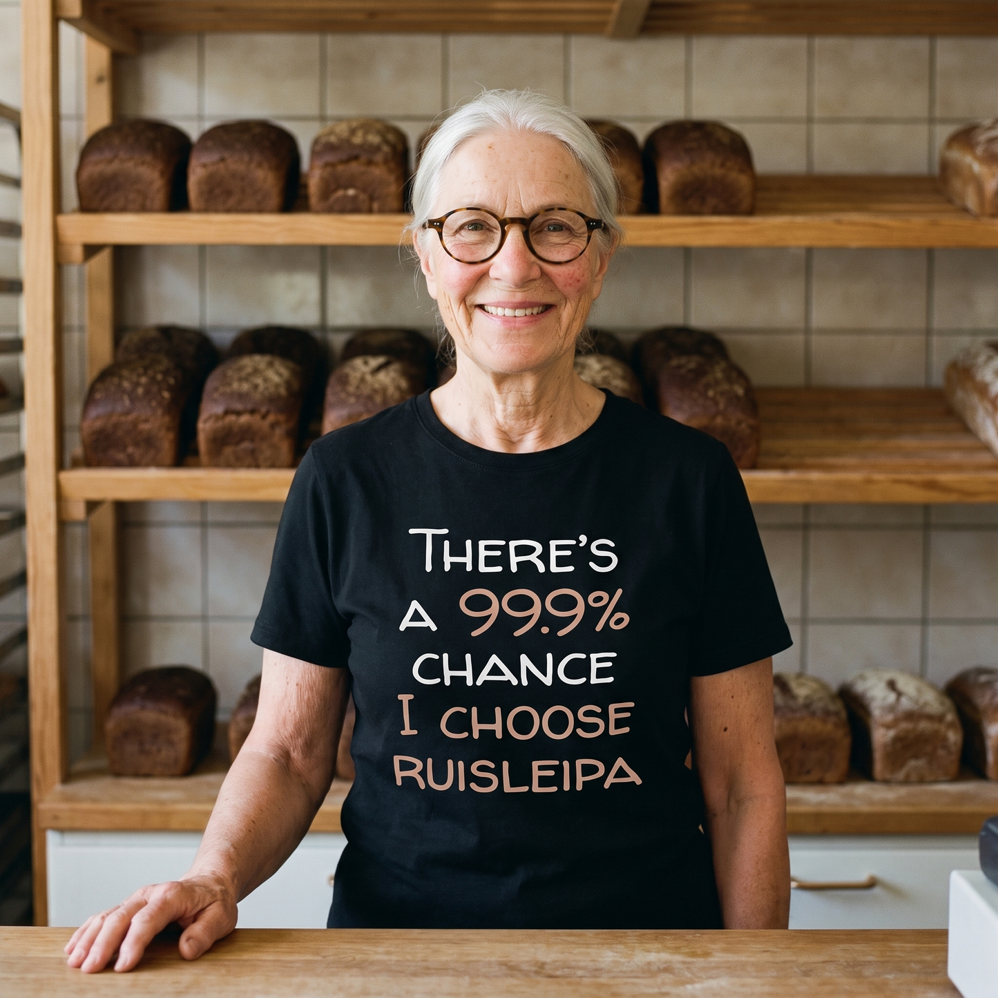 99.9% Chance I Choose Ruisleipa t-shirt in black, worn by a woman in a bakery, Very Finnish Problems