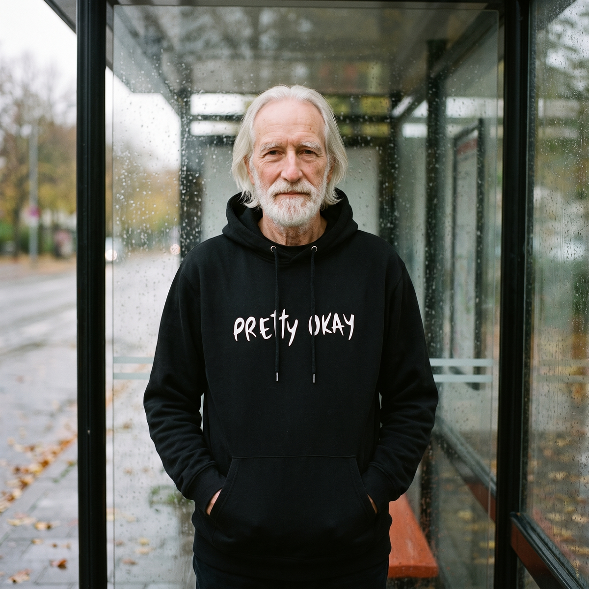 Pretty okay Finnish humour hoodie in black, worn by Pertti in a bus shelter, Very Finnish Problems