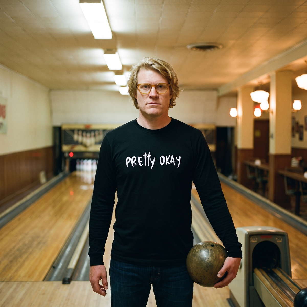 Pretty okay Finnish humour long sleeve tee in black, worn by Tuomas in a bowling alley, Very Finnish Problems