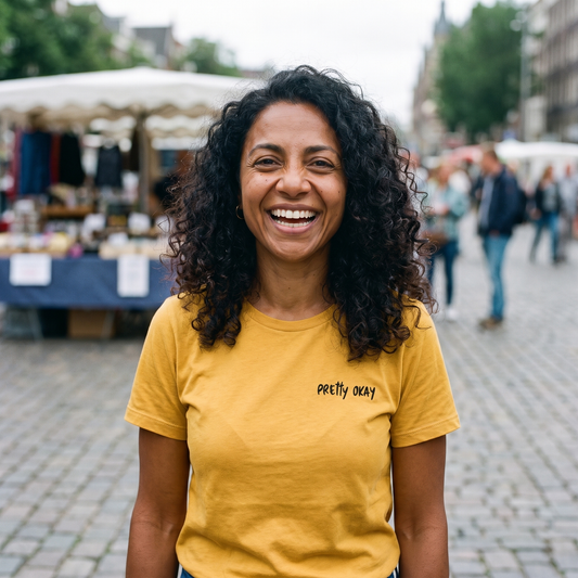 Pretty okay embroidered Finnish humour t-shirt in gold, worn by Nea on a market square, Very Finnish Problems