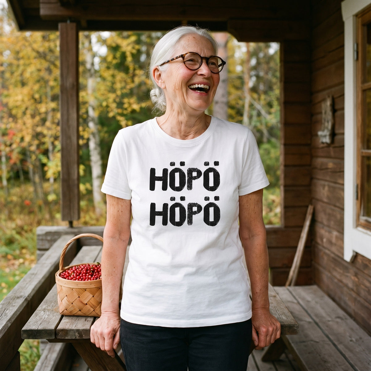Höpö höpö Finnish language t-shirt in white, worn by a woman laughing beside a basket of lingonberries on a cottage porch, Very Finnish Problems