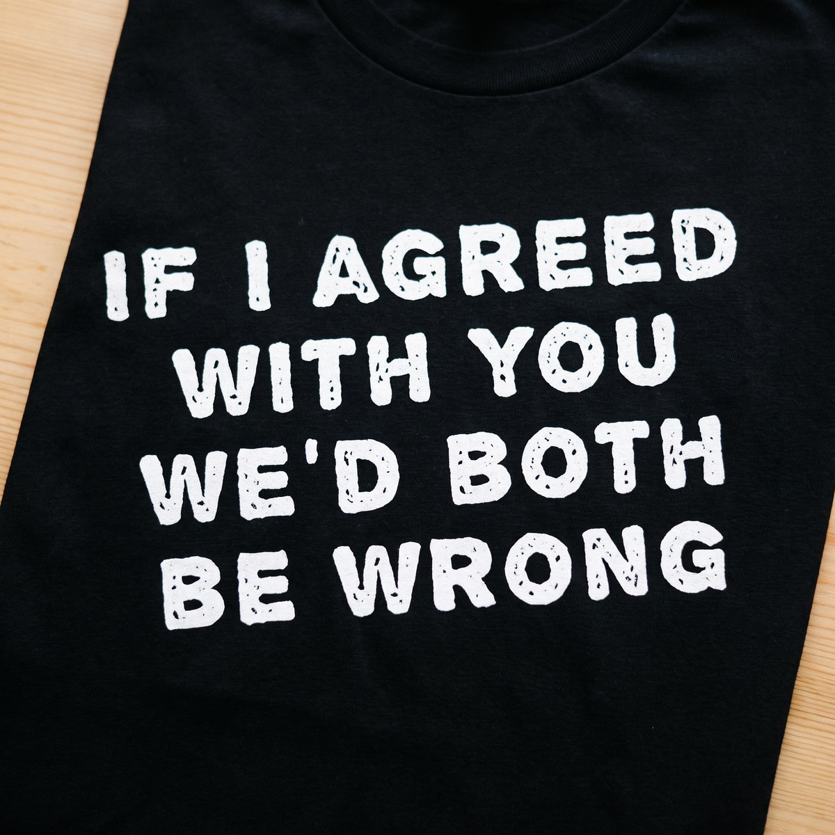 Close-up of the If I agreed with you we'd both be wrong print on black t-shirt fabric, Very Finnish Problems