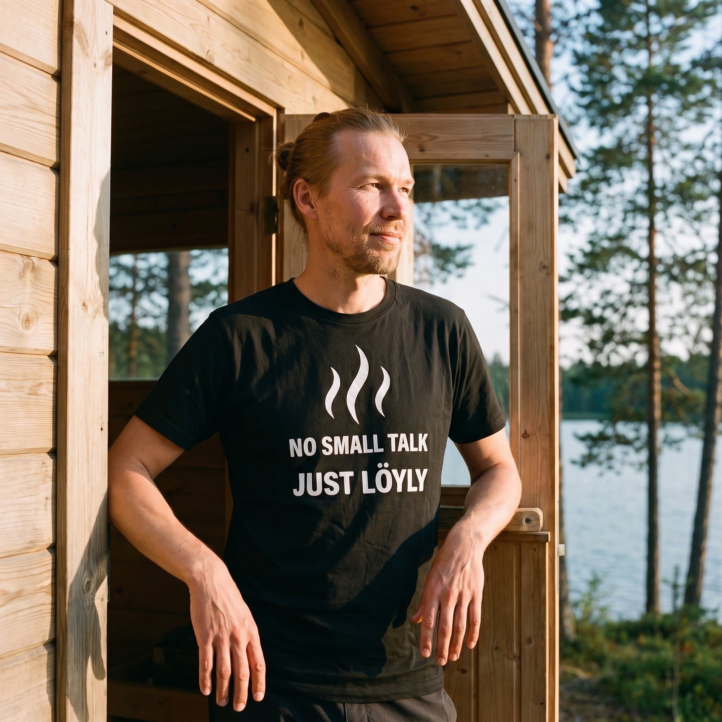 No Small Talk Just Löyly t-shirt in black, worn by a man in the doorway of a lakeside Finnish sauna, Very Finnish Problems