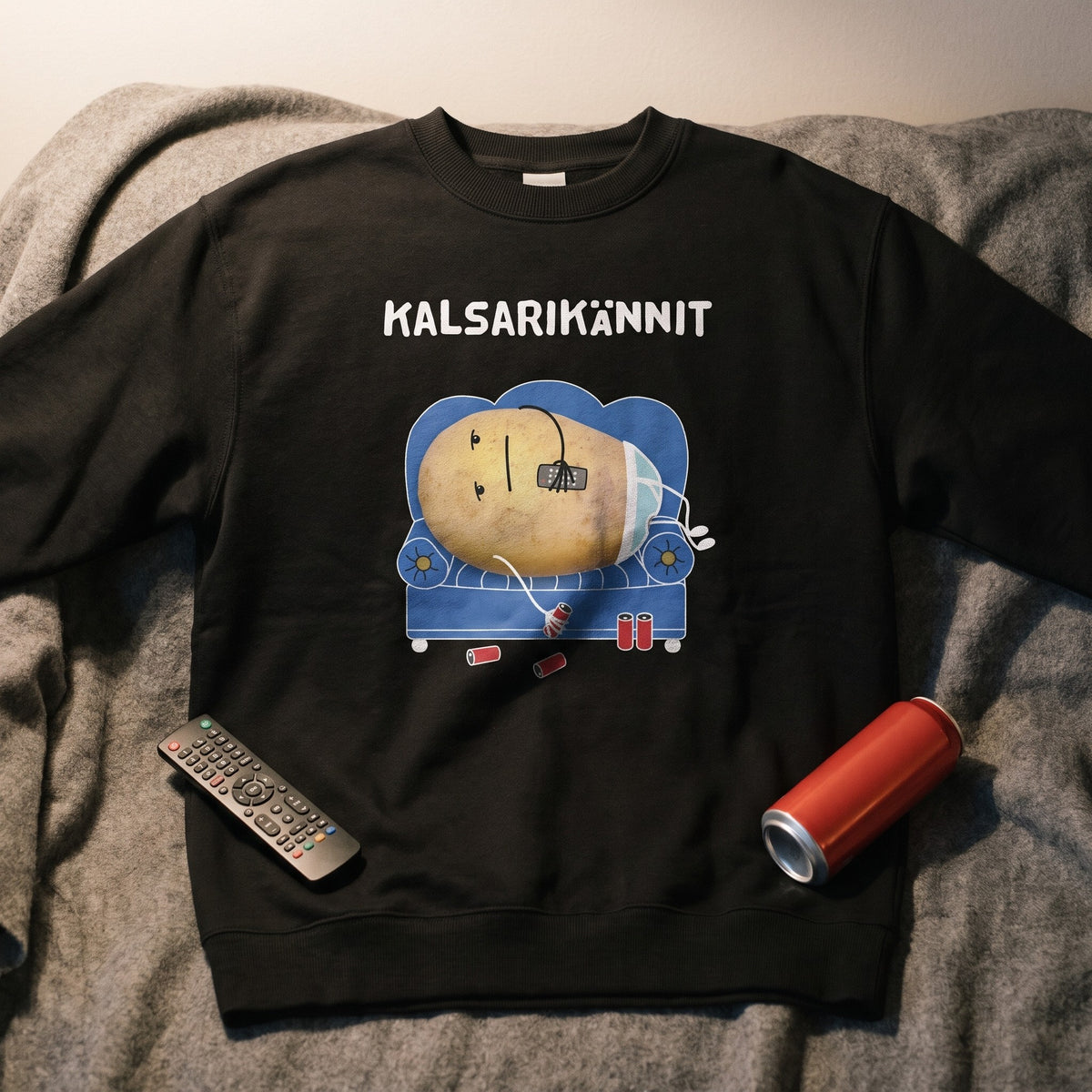 Close-up of the Kalsarikännit potato-on-the-sofa print on a black sweatshirt, Very Finnish Problems