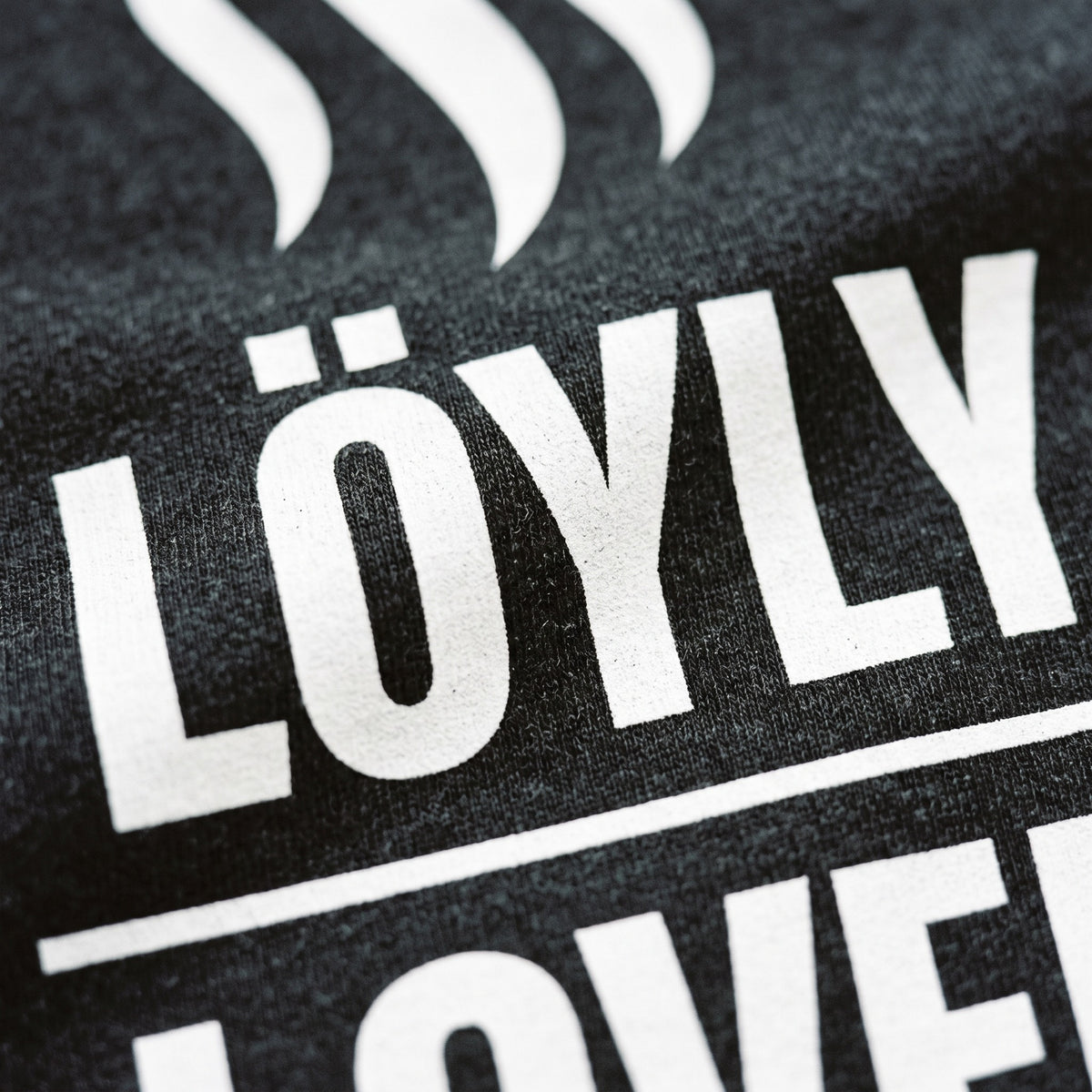 Close-up of the Löyly Lover print on black heather t-shirt fabric, Very Finnish Problems