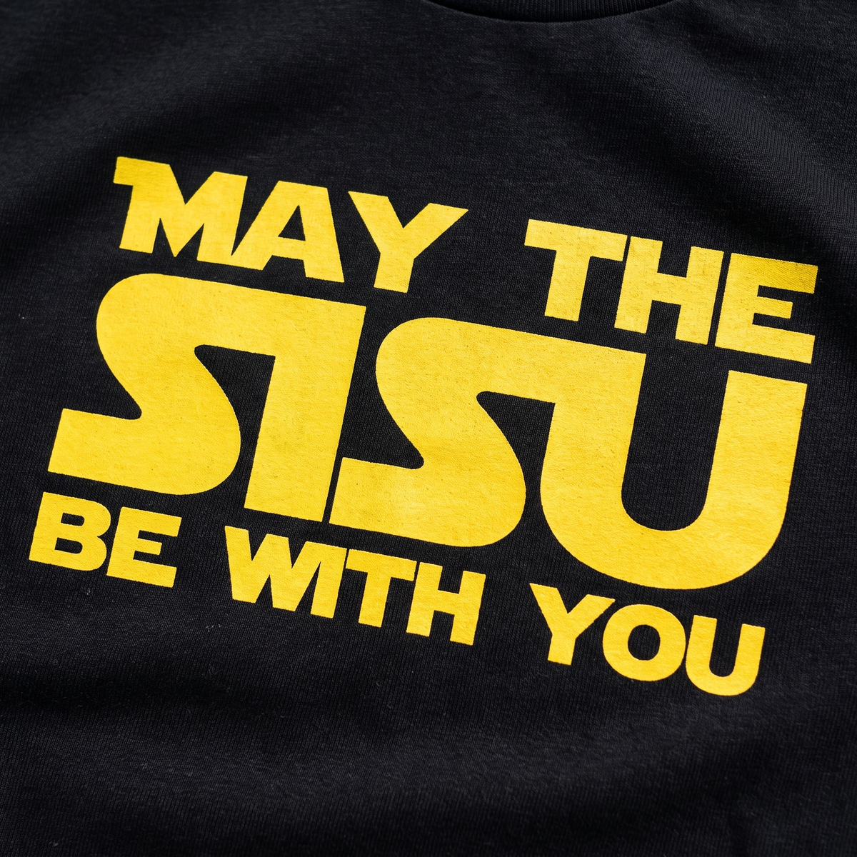 Close-up of the May the sisu be with you print on black fabric, Very Finnish Problems
