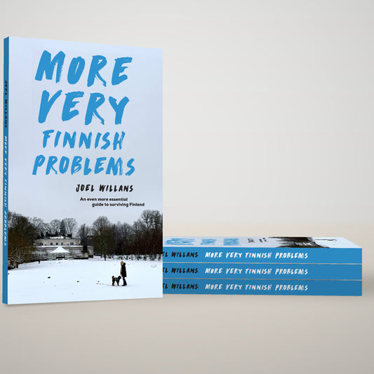 More Very Finnish Problems paperback standing beside a stack of copies, by Joel Willans