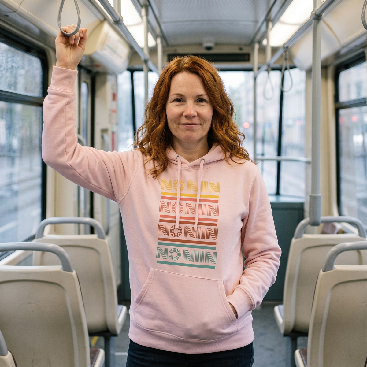 No niin retro Finnish language hoodie in light pink, worn by Sanna on a Finnish tram, Very Finnish Problems