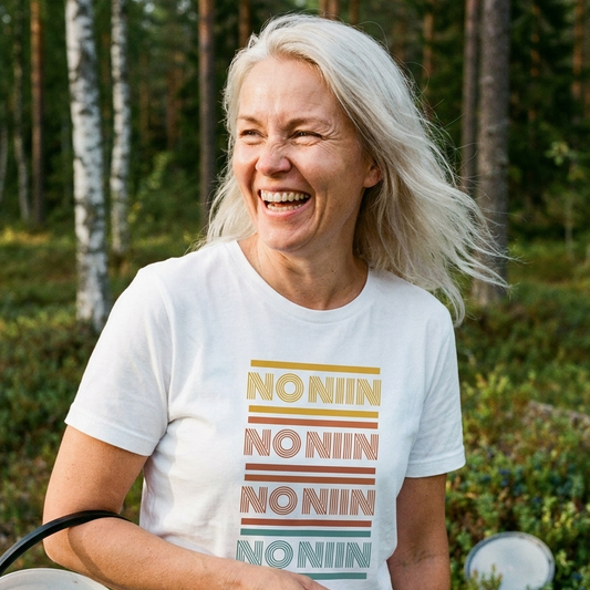 Woman laughing in a Finnish forest wearing the white No niin retro Finnish language t-shirt by Very Finnish Problems