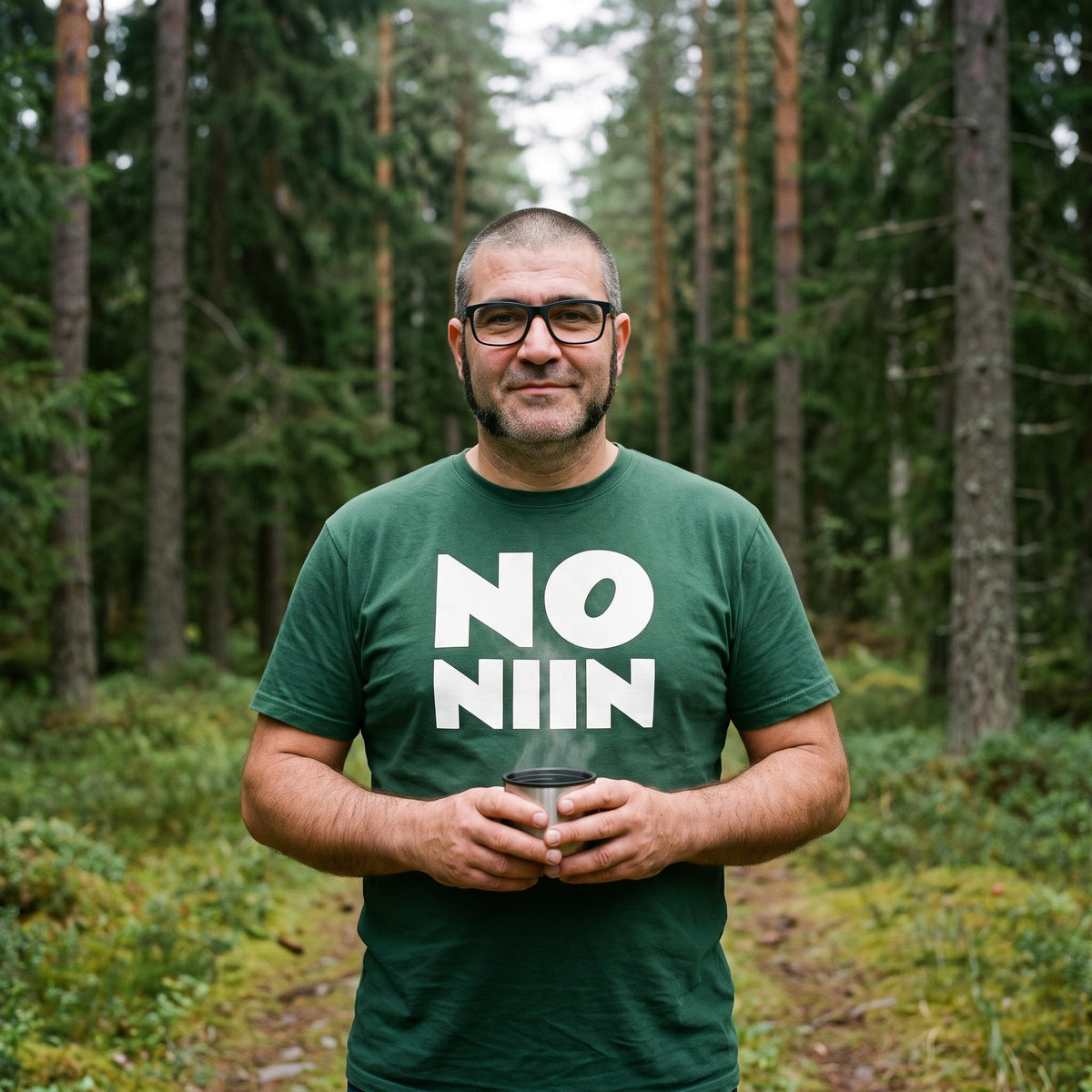 Jaska wearing the forest green No niin stacked t-shirt on a spruce forest track, Very Finnish Problems