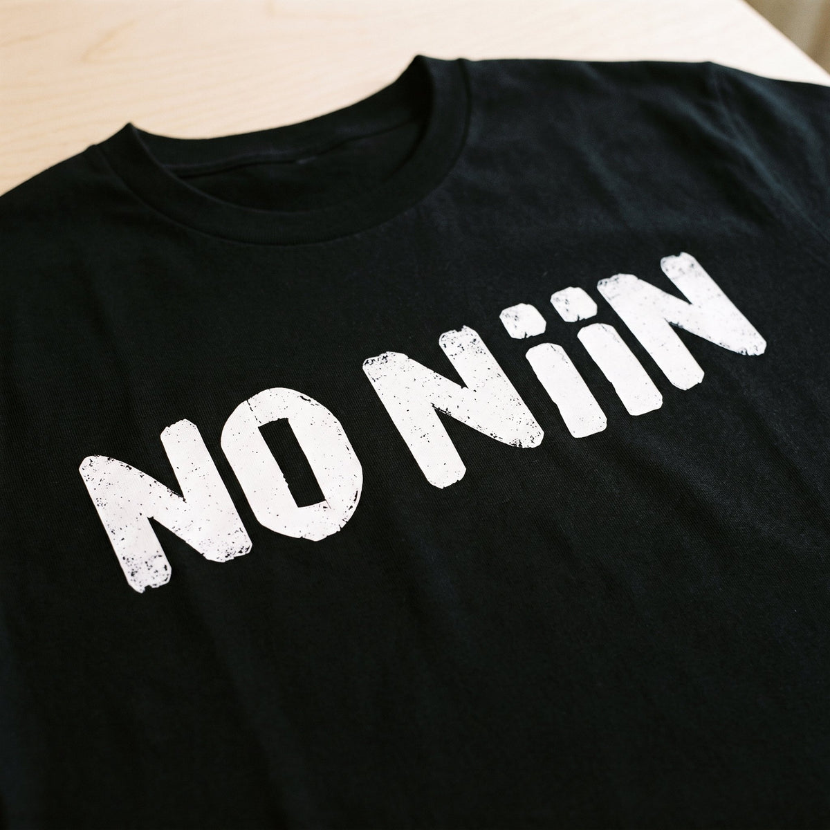 Close-up of the No niin print in white on a black t-shirt, Very Finnish Problems