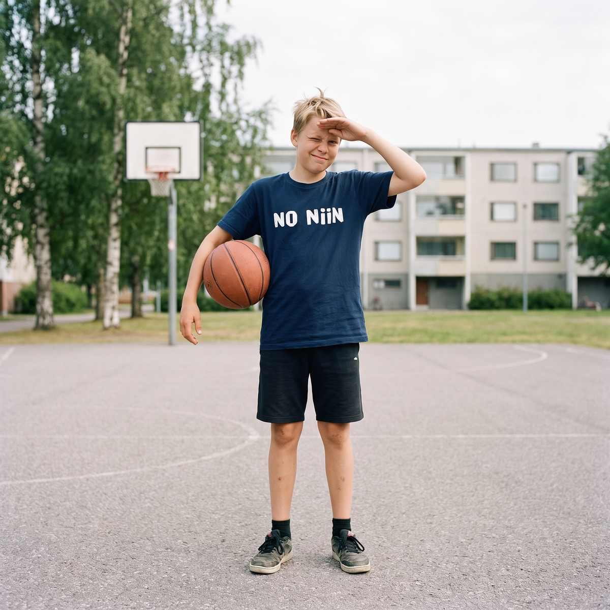 No niin Finnish language youth t-shirt in navy, worn by Onni on a Finnish basketball court, Very Finnish Problems