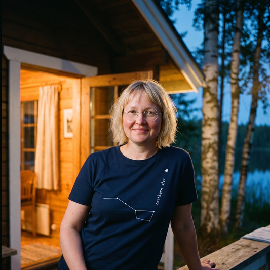 Northern Star 2 organic t-shirt in French Navy, worn by Marika on a summer cottage porch in the evening, Very Finnish Problems