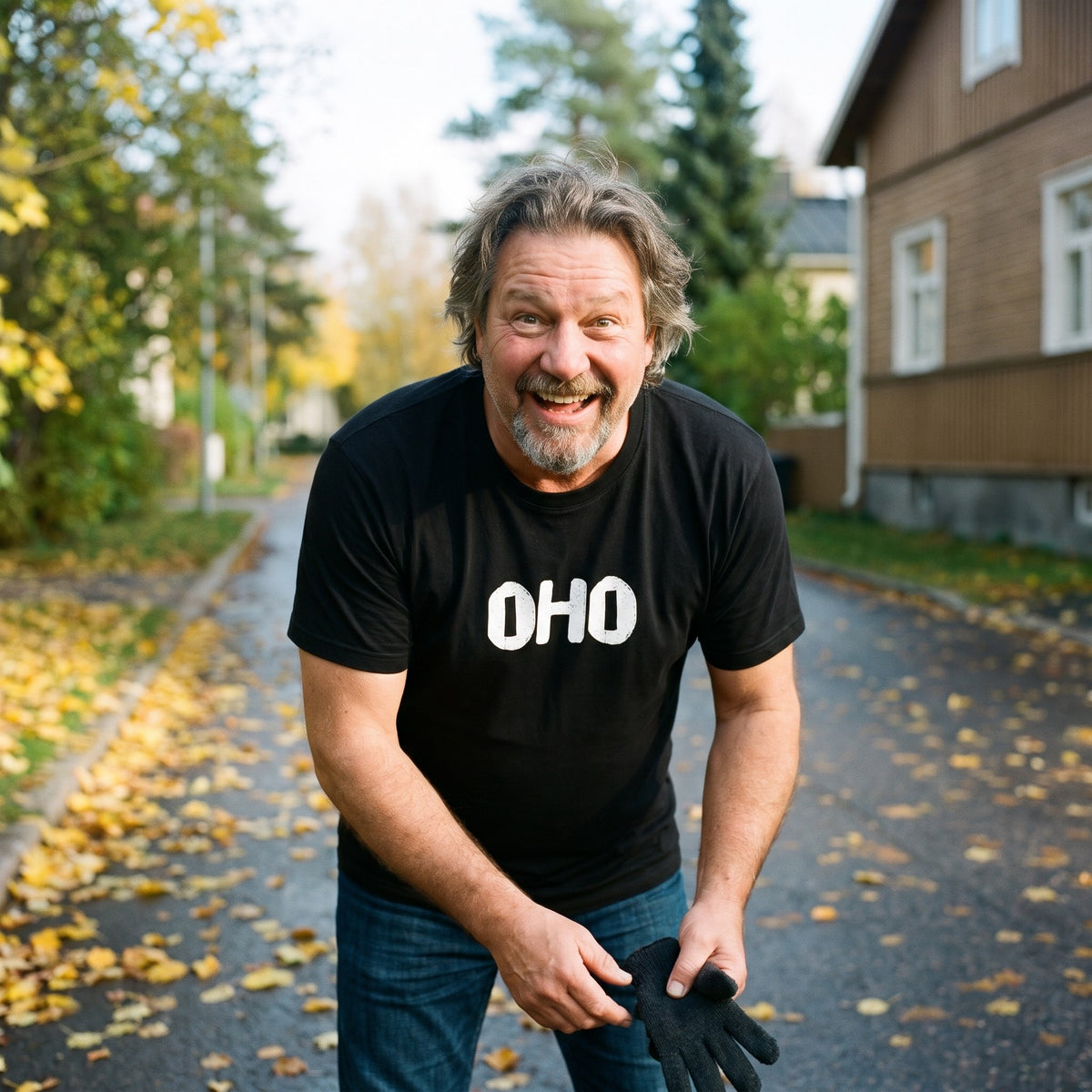 Oho Finnish language t-shirt in black, worn by a man grinning at a dropped glove on an autumn street, Very Finnish Problems