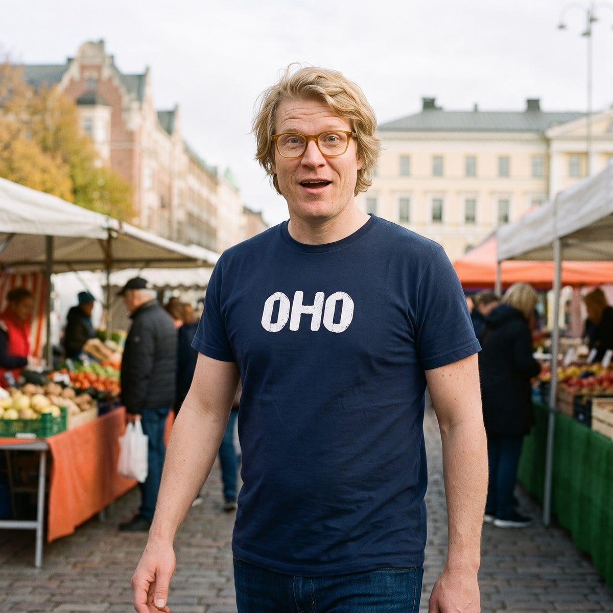 Oho Finnish language t-shirt in navy, worn by a man caught mid-step in amused surprise at a market square, Very Finnish Problems